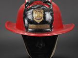 fireman ' s helmet on display on black base against a black background
