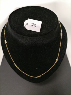 a close up of a black hat with a gold necklace on it