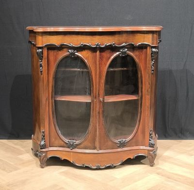 an antique wooden cabinet with glass doors on a wooden floor
