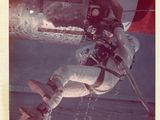 une vieille photo d'un homme en combinaison spatiale tenant un parapluie rouge