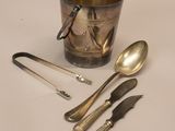 a silver cup with spoons and spoons next to it