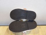 the bottom of a pair of white shoes on top of a wooden table