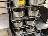 de nombreuses casseroles et poêles sur l'étagère de la cuisine