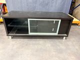 une photo d'un meuble TV avec une porte vitrée
