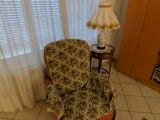 un salon avec un fauteuil et une lampe