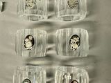 six clear glasses with silver and silver coins in them
