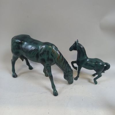 deux figurines représentant un cheval et un poulain posées sur une table