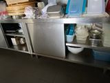 une cuisine avec des placards en inox et un plan de travail