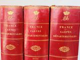 three red books sitting on top of each other on top of a table