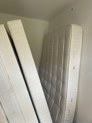 two mattresses stacked on top of each other in the corner of a room