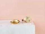 a pair of gold cuff rings on a marble block