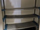 a metal shelf with blue shelves in the corner of a room