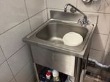 a sink in the corner of a bathroom with a mirror above it