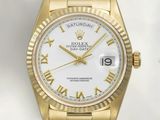 une montre Rolex en or avec des chiffres romains et un cadran blanc