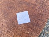 a small sticker on a wooden table that is on the ground