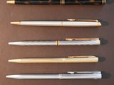 four different types of pens lined up on top of a table