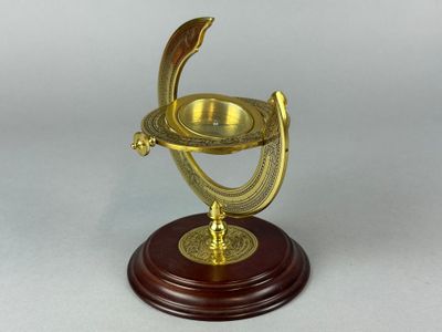 une horloge plaquée or posée sur un socle en bois