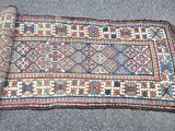 un tapis posé à même le sol, sur lequel se trouve un rouleau de tissu
