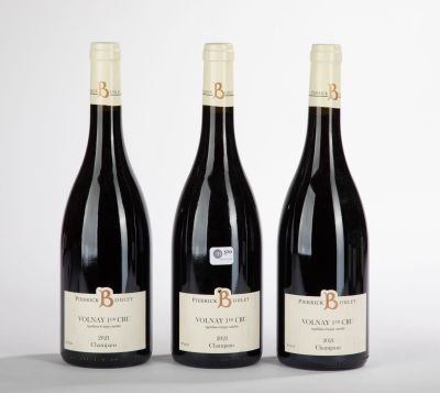 trois bouteilles de vin rouge sont alignées sur une table