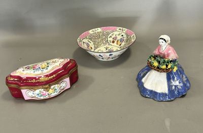 three small ceramic figurines of women and a bowl of flowers