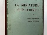 un vieux livre posé sur une table à côté d'un mur blanc