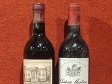 deux bouteilles de vin posées sur une table près d'un mur orange