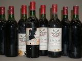 six bouteilles de vin rouge sont alignées sur une table