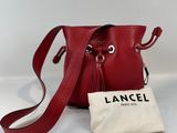 un petit sac seau rouge muni d'un cordon de serrage et d'un cordon de serrage