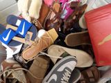 many pairs of shoes and bags in a pile