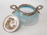 a blue glass jar with a silver lid on a table