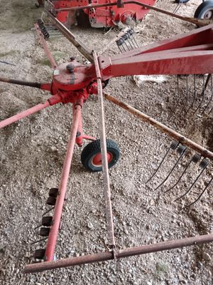 un tracteur rouge garé sur la terre battue