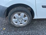 une petite voiture blanche avec un pneu crevé sur la route