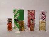 four different perfumes are lined up in a row on a table