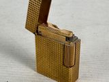 a gold lighter that is sitting on a white surface