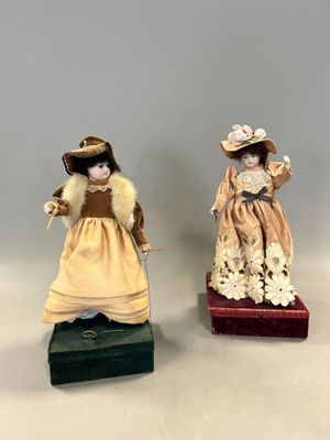 paire de figurines en porcelaine représentant des dames en robe et chapeau
