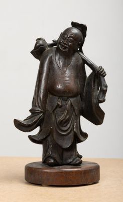 statue représentant un homme tenant un sac, posée sur un socle en bois