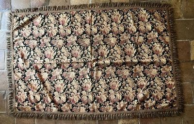 un tapis posé à même le sol, orné d'un motif floral