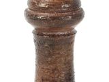 a small wooden pepper mill on a white surface