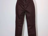 le mannequin tient un pantalon marron sur son support