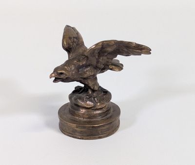 une statue représentant un aigle sur un socle, sur fond blanc