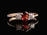 un gros plan d'une bague sertie d'un diamant rouge et blanc sur une surface noire
