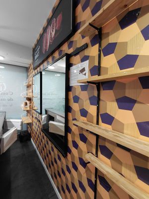 un mur de rayonnages dans un magasin, sur lequel est posé un téléviseur