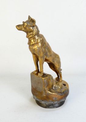 statue en laiton représentant un chien debout sur un rocher, avec un collier autour du cou