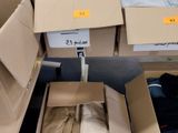 Des cartons de vêtements sont empilés les uns sur les autres dans un entrepôt.