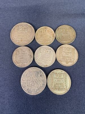 six different british coins are arranged in a row on a blue cloth