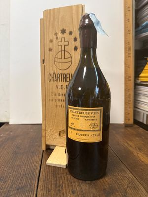 une bouteille de vin posée sur une table à côté d'une caisse en bois