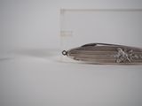 a small knife that is laying on a white surface