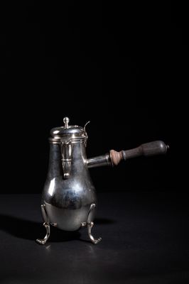 a silver coffee pot with a wooden handle on a black surface