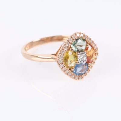 gros plan d'une bague en or avec des pierres multicolores