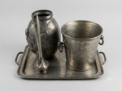 un plateau en argent sur lequel se trouvent un vase en argent et une coupe en argent